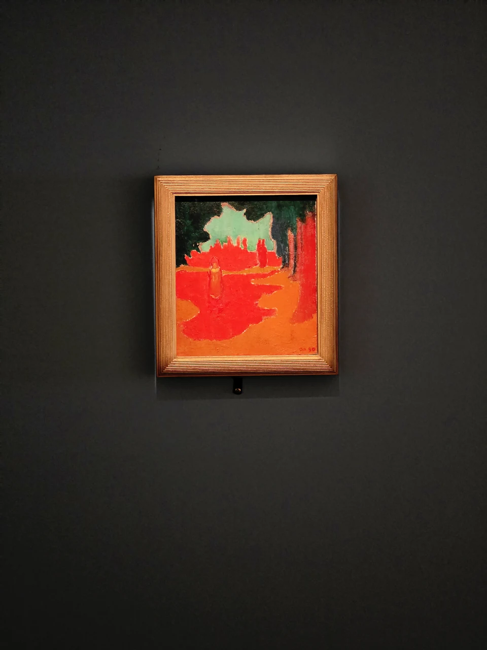 Un tableau rouge et vert sur un mur sombre
