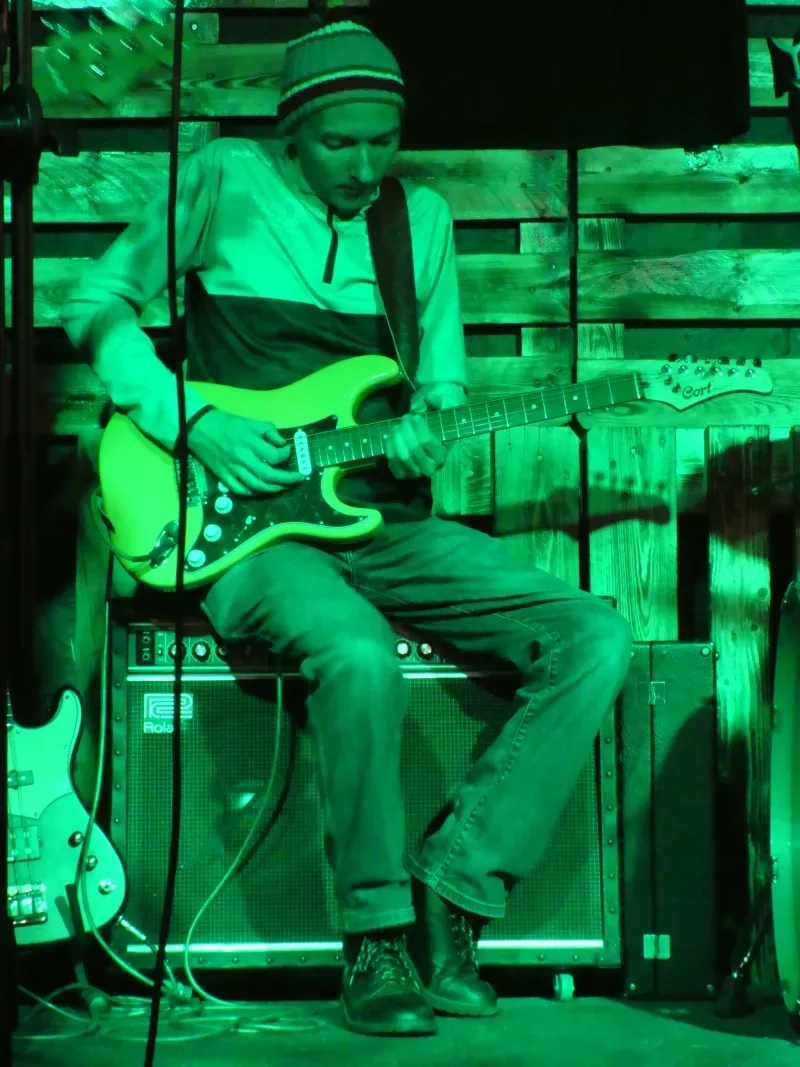 Adam Zaklukiewicz grający na gitarze (portret sceniczny)